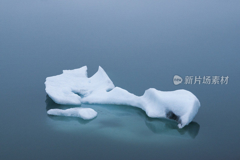 冰山漂浮在平静的海面上，冰岛