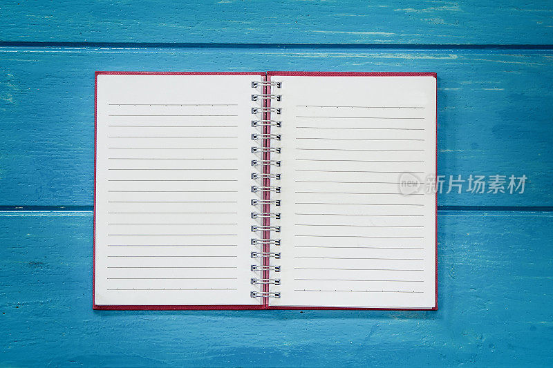 蓝色木桌上的空白笔记本