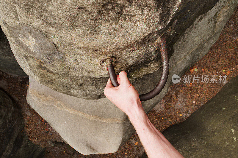 岩石攀岩者的手在砂岩的手扶。通过ferrata。