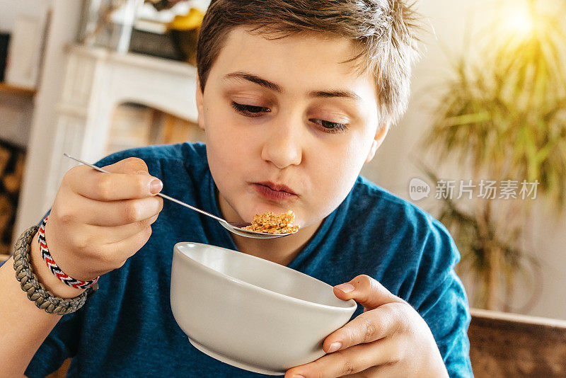 法国少年从杯子里吃麦片的肖像