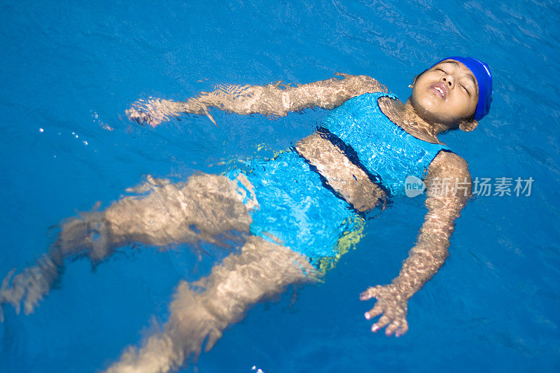 一个印第安小女孩在游泳池里漂浮着