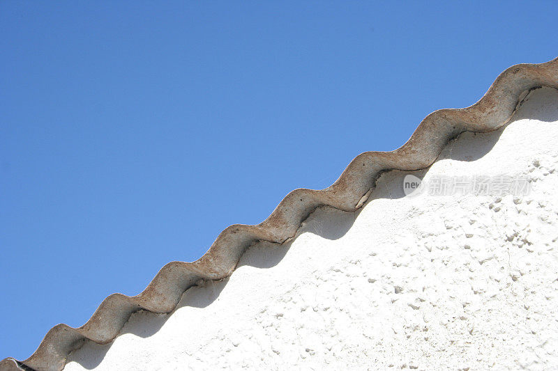 白色墙壁上的波浪形锡金属屋顶