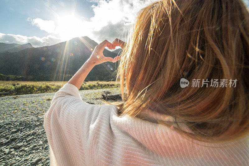 河边的女人做了心形的手指架