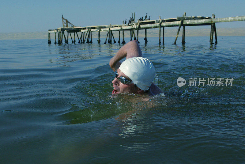 在有防波堤的海里游泳的人