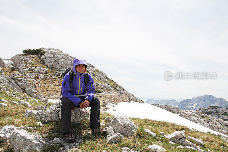 年轻女性徒步旅行者在登山途中休息