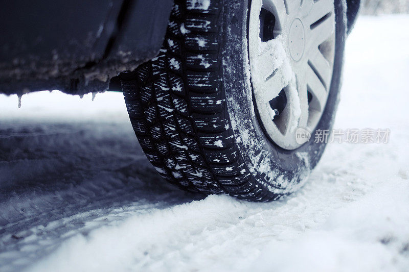 近距离的汽车冬季轮胎在雪