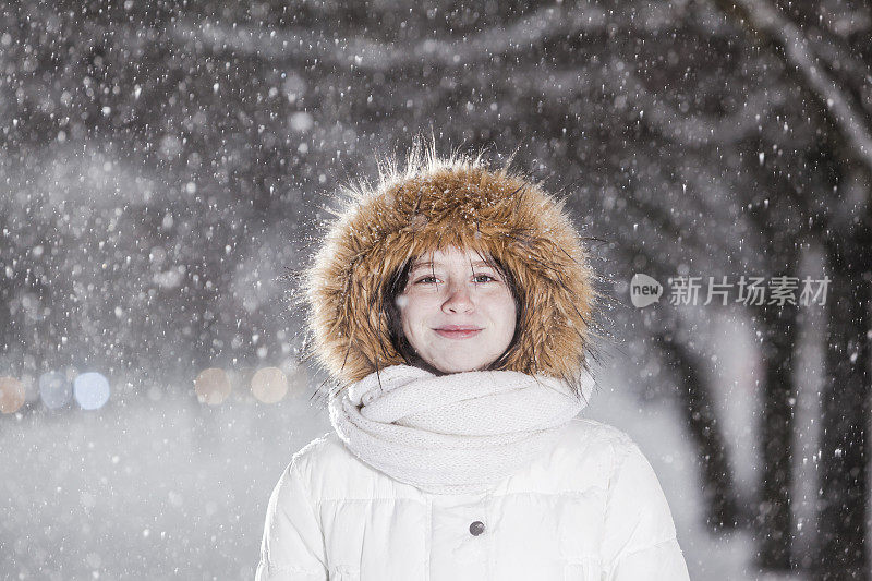 雪下穿着白色夹克的漂亮少女