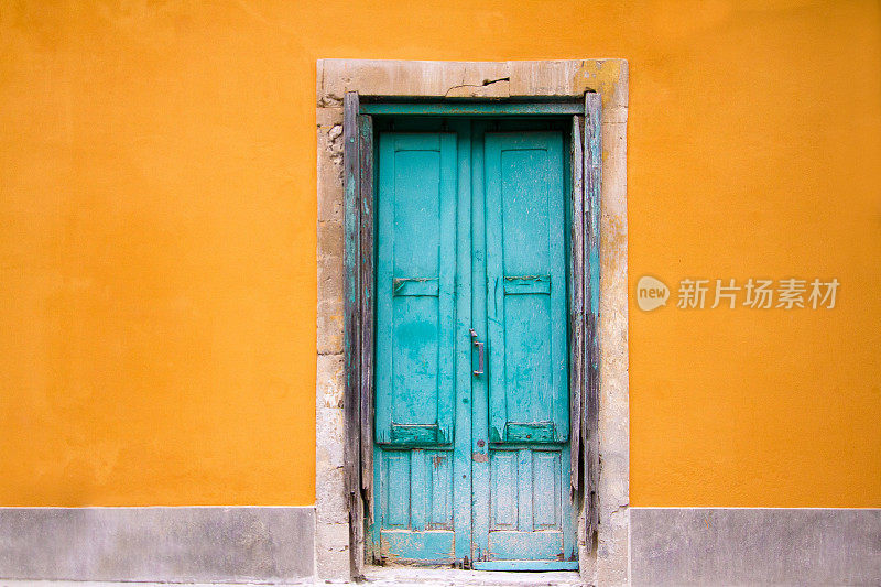 旧绿松石门在充满活力的橙色墙，西西里岛