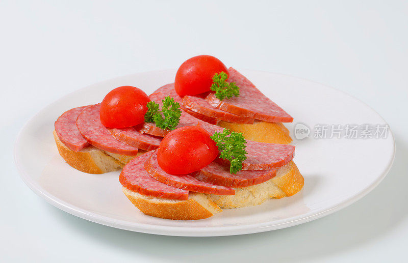 配意大利腊肠、樱桃番茄和欧芹的面包片