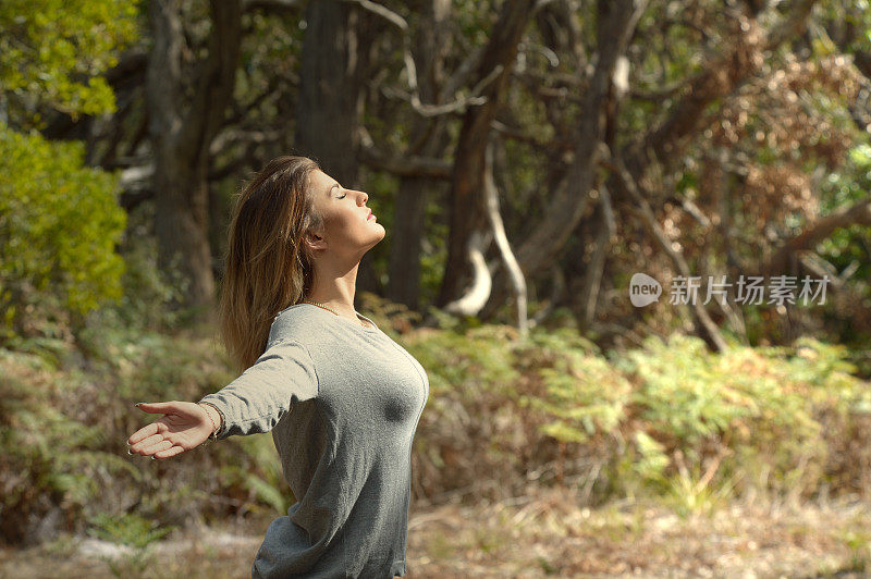 年轻女人感觉自由-澳大利亚丛林日落