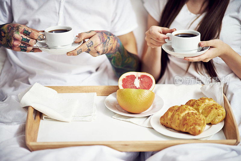 年轻夫妇在床上吃早餐