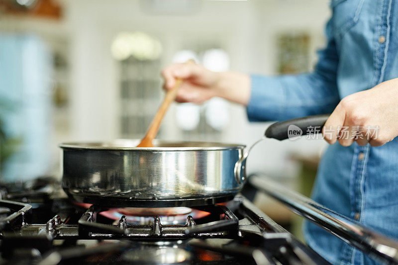 女人在煎锅里煮食物的特写