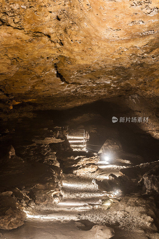灯光照亮的步道和栏杆，参观拉巴尔姆洞穴