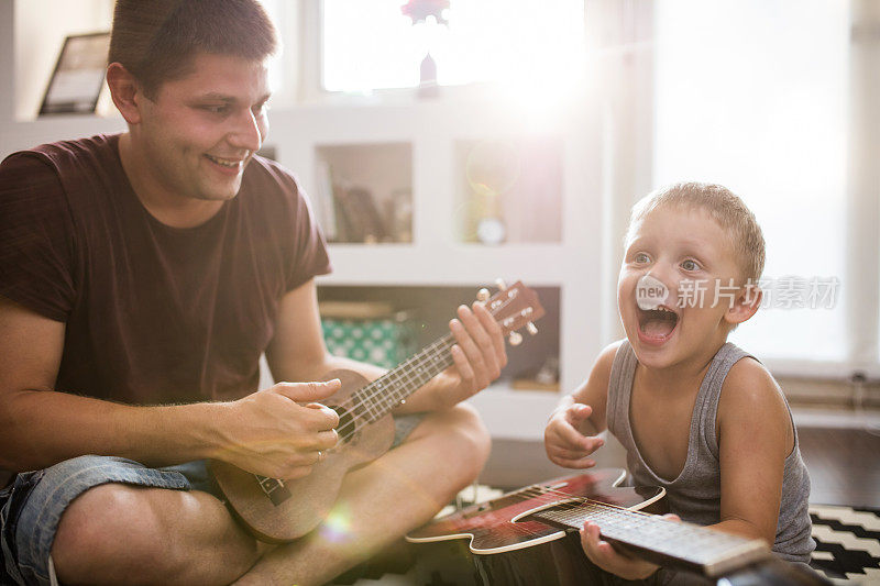 可爱的父亲和儿子一起弹吉他，镜头光晕
