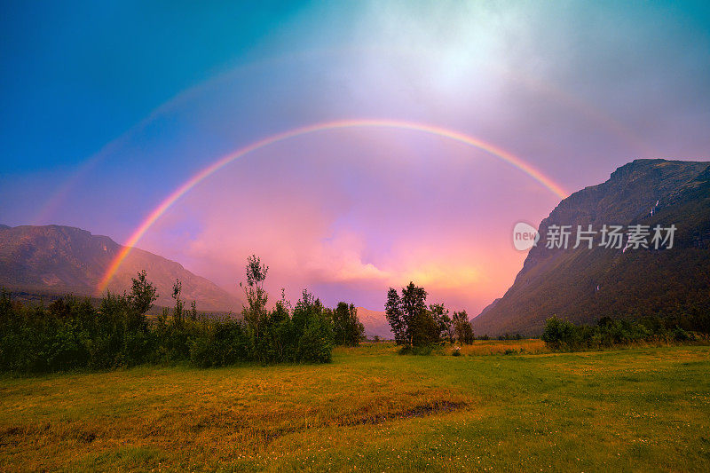 美丽的彩虹在日落时越过山脉。荒野挪威