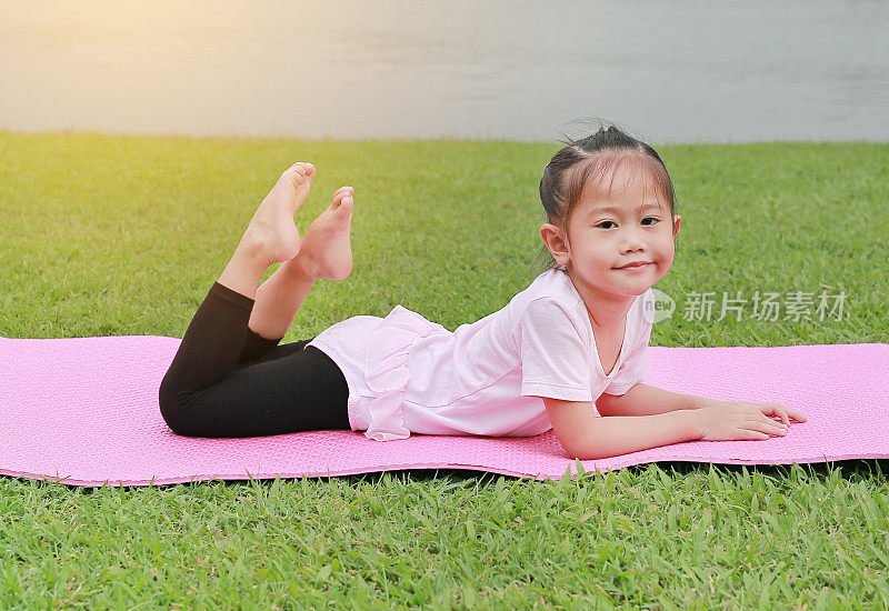 一个亚洲小女孩在公园里做瑜伽。