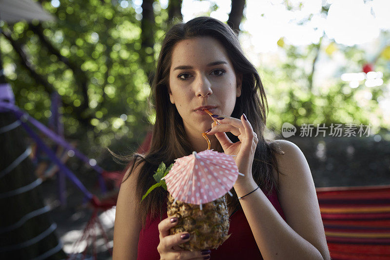 游园会。年轻女子喝热带饮料