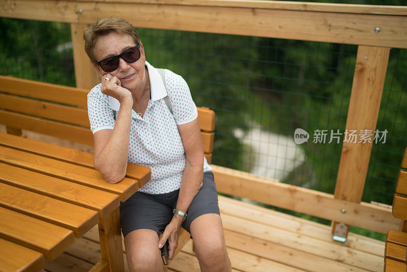 一位疲惫的70岁老妇坐在长椅上
