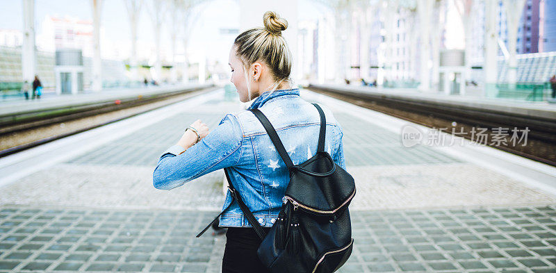 女子旅行者背包在火车站检查时间