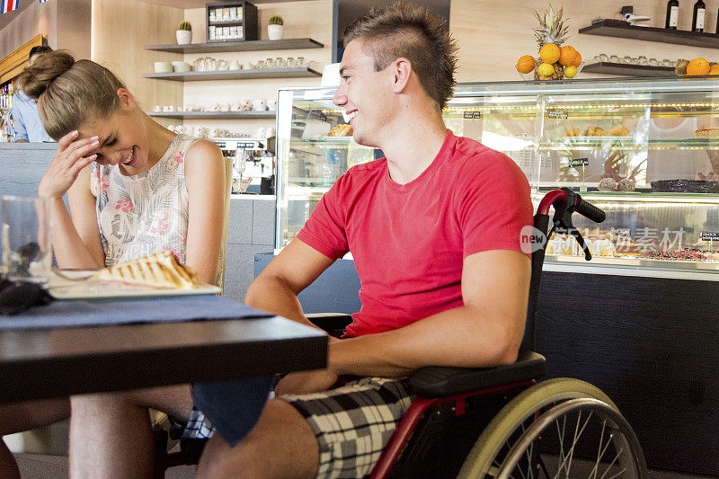 一个年轻的残疾人和女朋友在咖啡馆