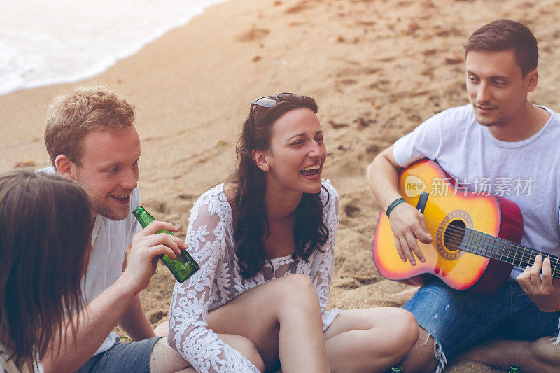 一群人在海滩上听吉他