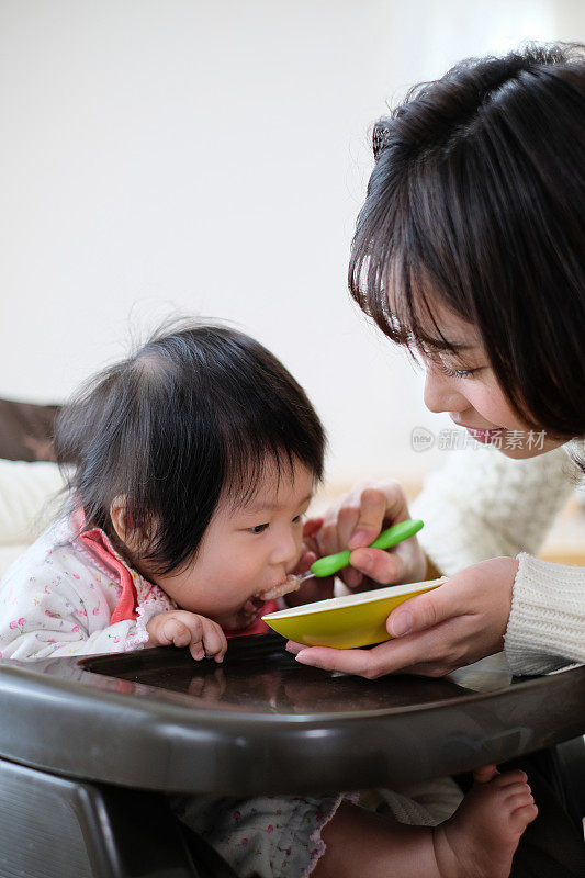 母亲给婴儿喂食物