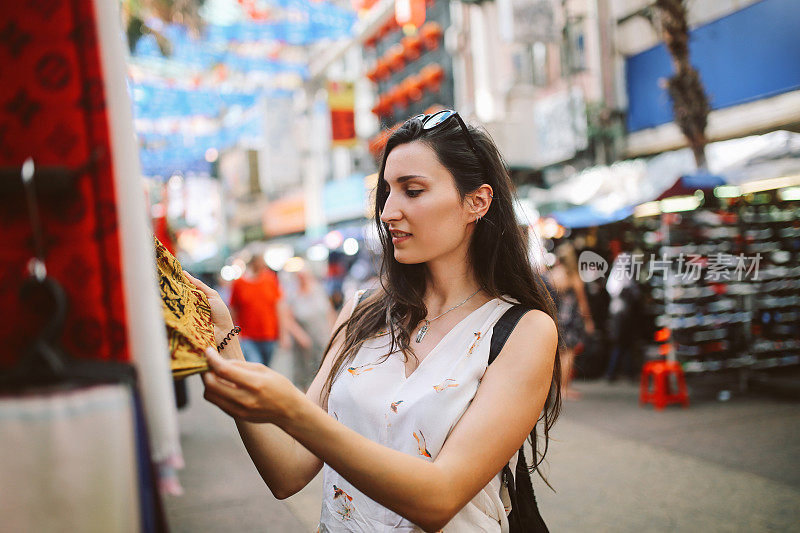 年轻的旅行者女人在吉隆坡唐人街区购物