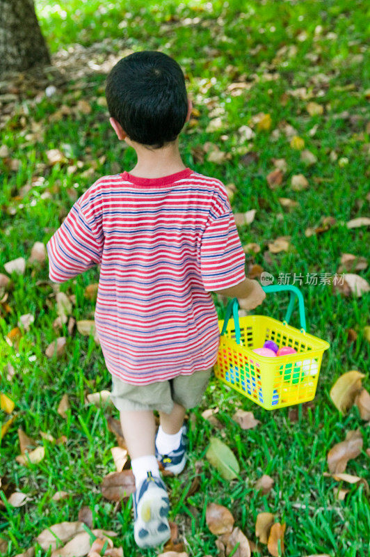 男孩带着复活节彩蛋篮子在户外奔跑