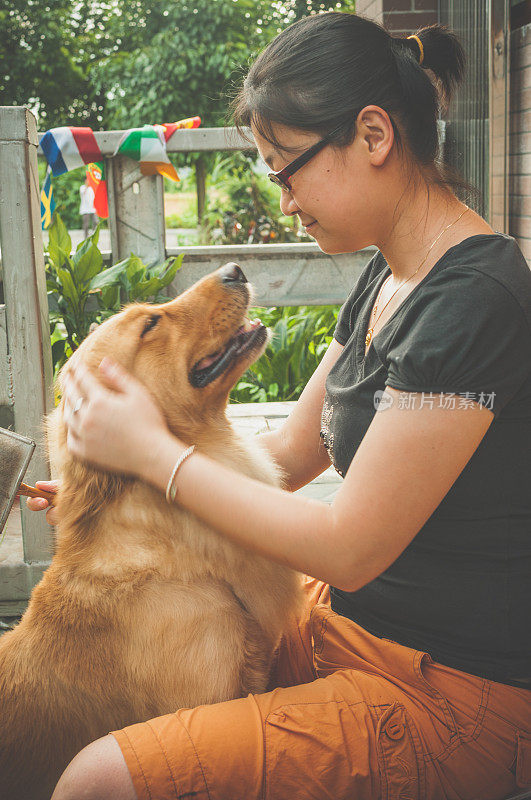 一个亚洲女人和一只金毛猎犬