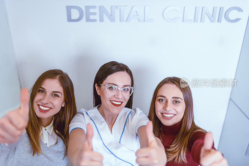 酷酷的牙科同事在诊所里竖起大拇指摆姿势