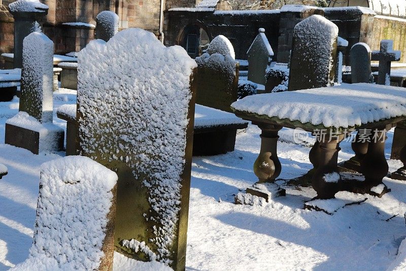 白雪覆盖的墓地里的坟墓、墓碑和墓碑