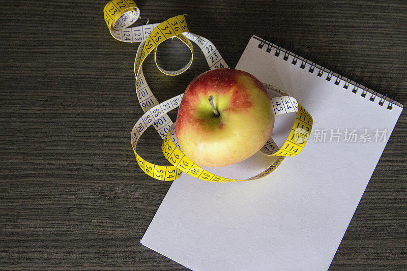 用卷尺测量新鲜苹果。