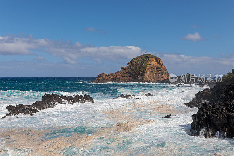 在多岩石的海岸上击碎波浪