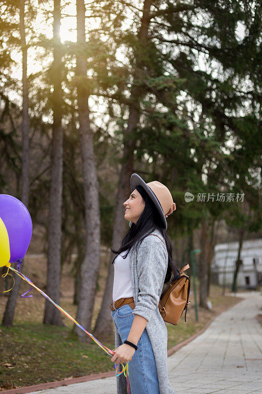 一个年轻女人在公园里玩氦气球