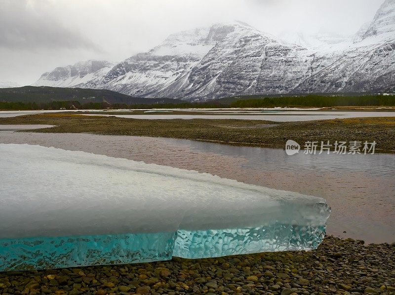 挪威峡湾卵石海滩上的蓝色冰山