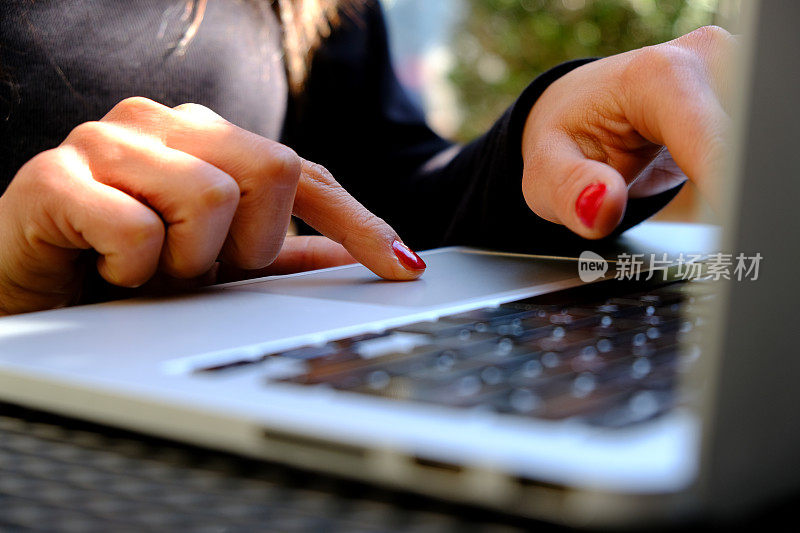 女性在笔记本电脑键盘上打字的特写