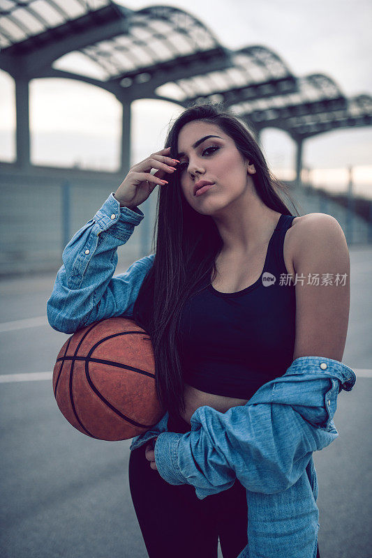 轻浮女性在球场上玩篮球