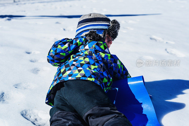 在公园玩雪橇的男孩