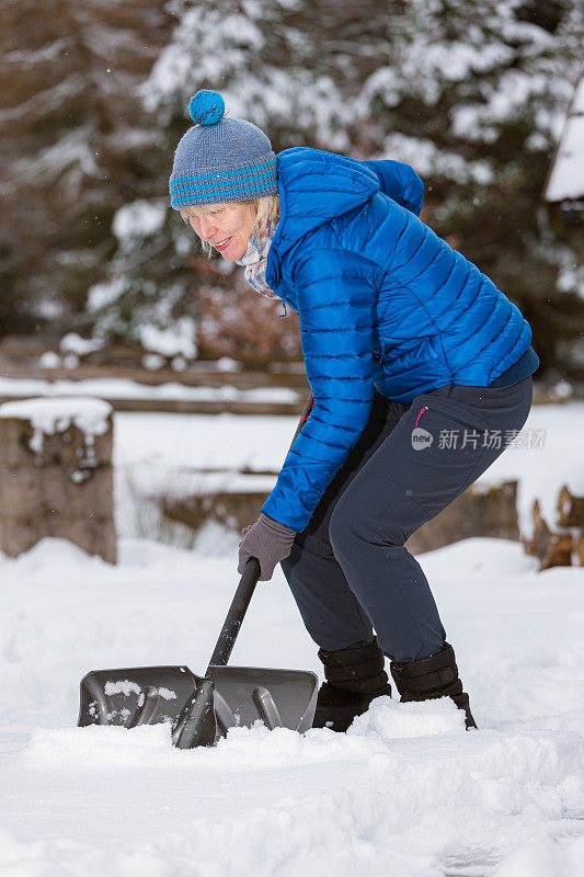 老妇人拿着雪铲