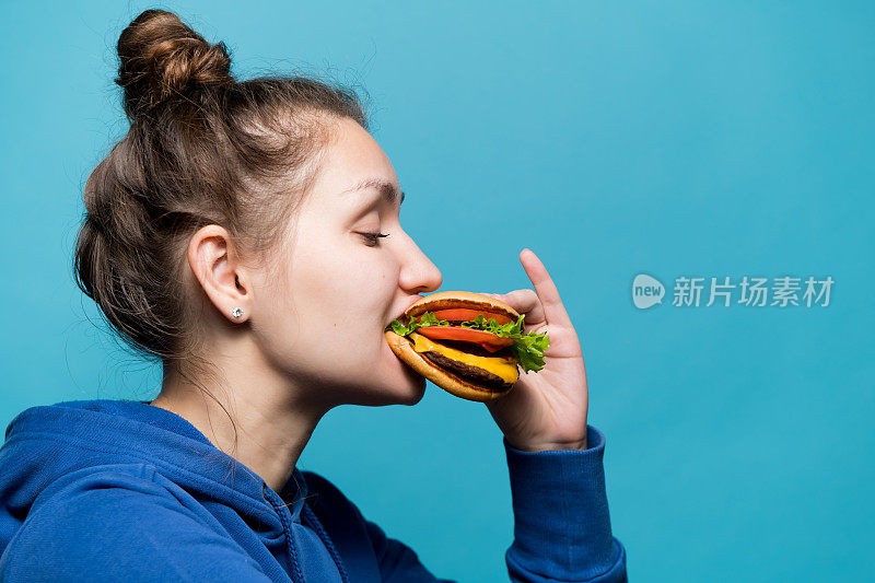 一个女孩在吃三明治的侧面