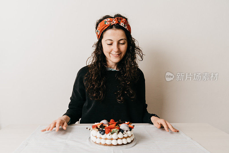 一个女人正在家里用奶油馅饼庆祝她的生日