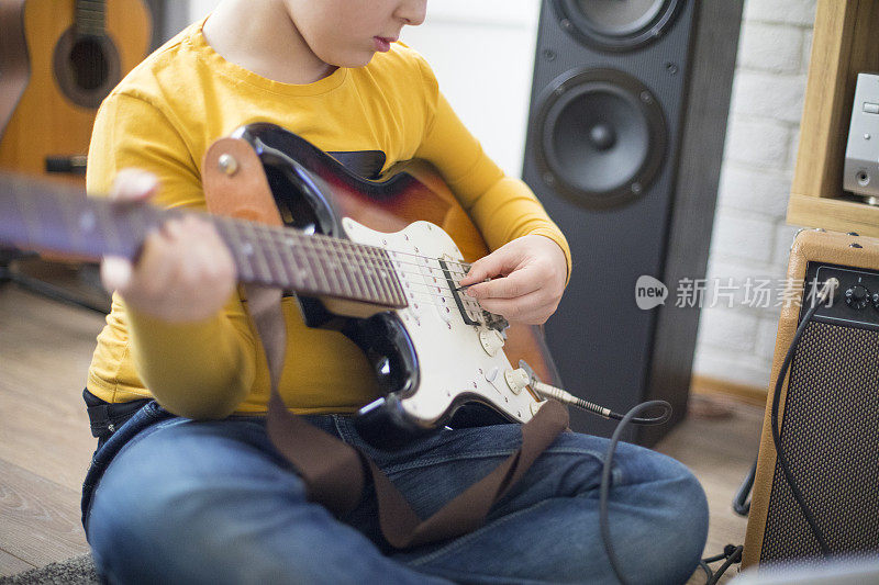小男孩在家弹电吉他