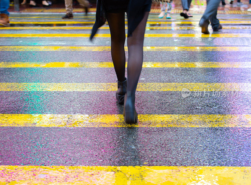 香港，妇女过马路。雨湿斑马线