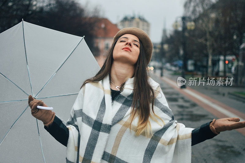 美丽的年轻女子享受着雨天