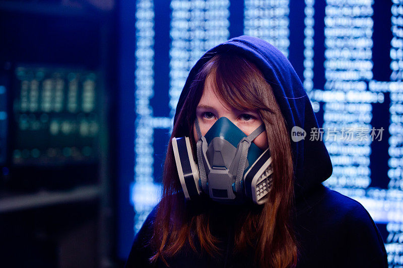 一个戴着防护面具的黑客女孩在她的巢穴里执行她的新程序
