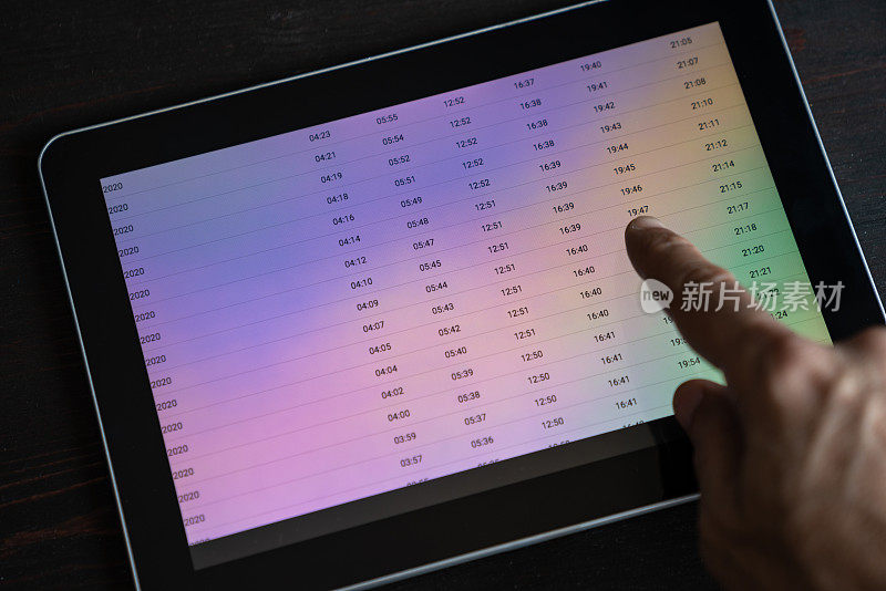 近距离照片的人的手检查时间开斋在数字平板电脑上