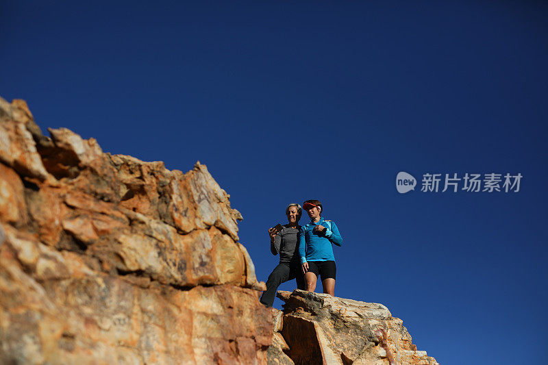 两个女性朋友站在一块岩石上自拍