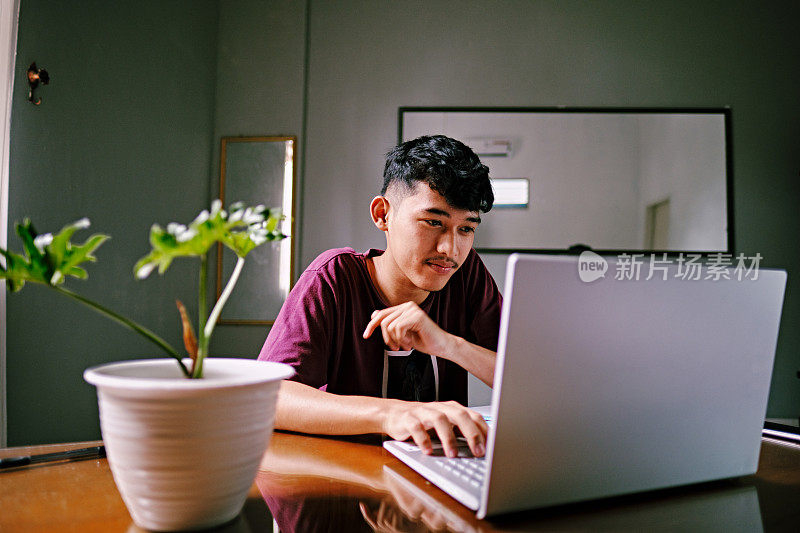 一名印尼男子用笔记本电脑在网上购物