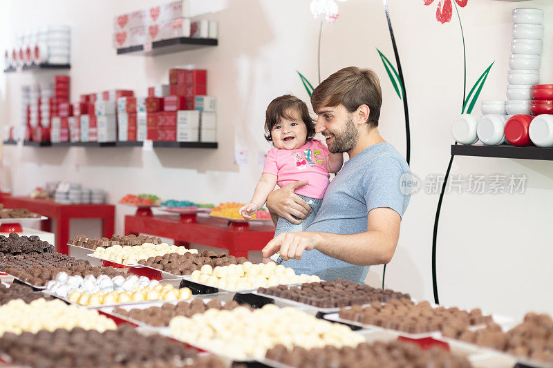 父亲和一个快乐的小女孩在巧克力店