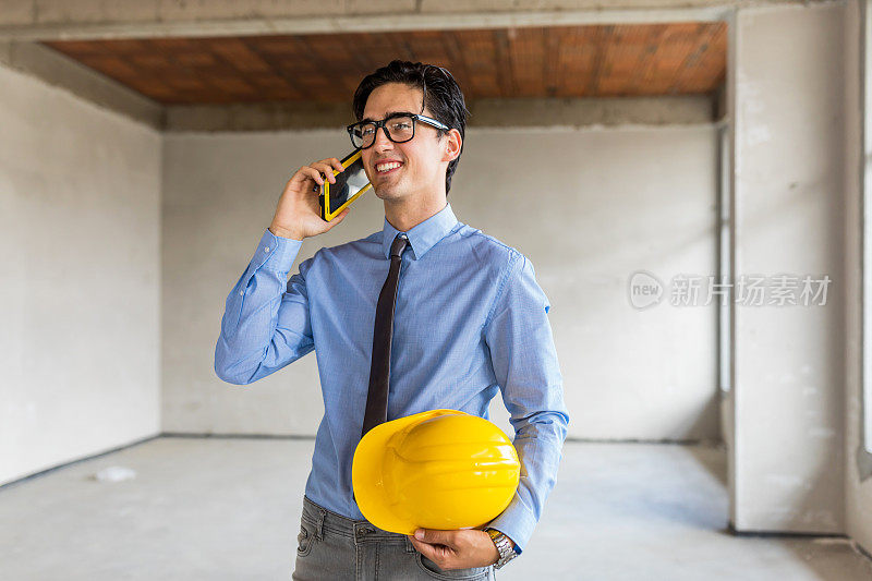 土木工程在建筑工地工作时使用智能手机。